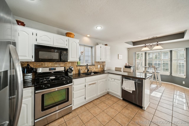 kitchen with stainless steel appliances, sink, kitchen peninsula, backsplash, and white cabinets