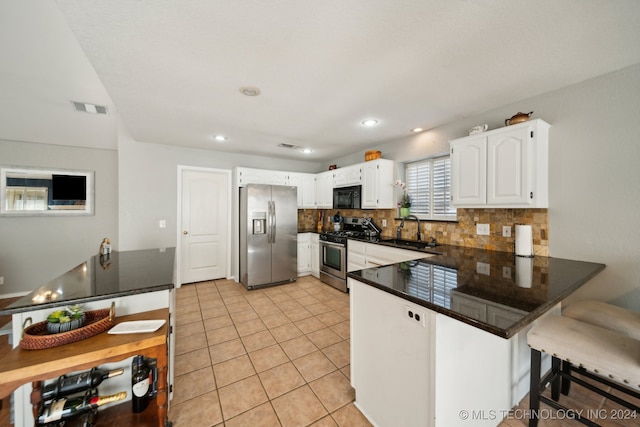 kitchen featuring sink, appliances with stainless steel finishes, tasteful backsplash, white cabinets, and tile patterned floors