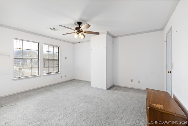 spare room featuring light carpet, ceiling fan, and crown molding