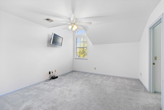 additional living space with light colored carpet, lofted ceiling, and ceiling fan