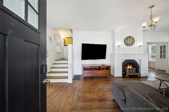 living room featuring dark parquet flooring and an inviting chandelier