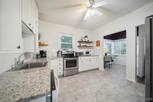 kitchen featuring a textured ceiling, sink, light stone countertops, white cabinetry, and appliances with stainless steel finishes