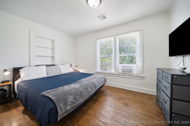 bedroom with cooling unit, dark hardwood / wood-style floors, and crown molding