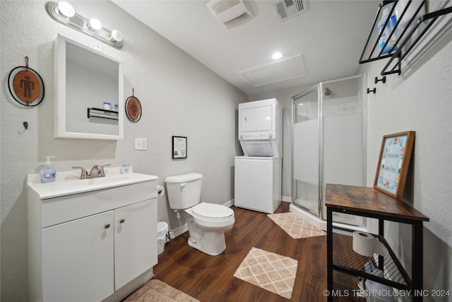 bathroom with hardwood / wood-style floors, vanity, stacked washer / dryer, and an enclosed shower