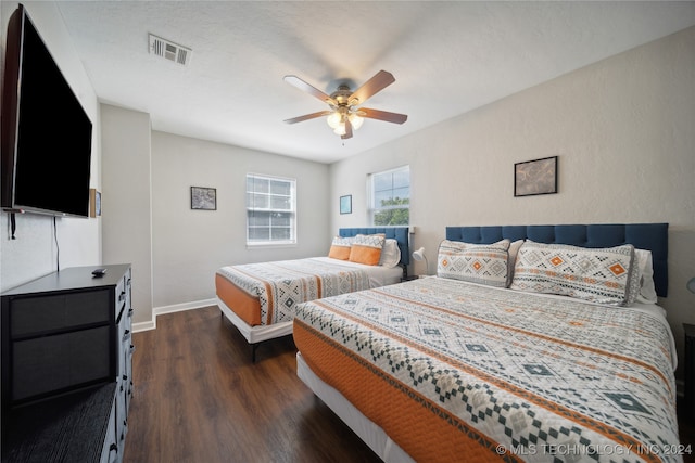 bedroom with dark hardwood / wood-style floors and ceiling fan