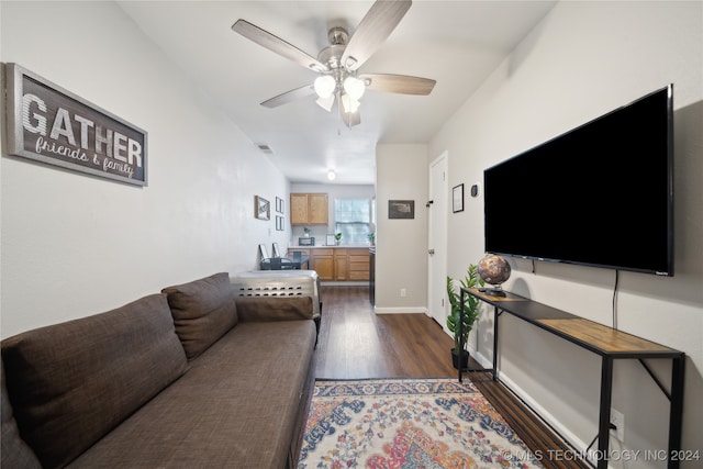 living room featuring dark wood-type flooring and ceiling fan