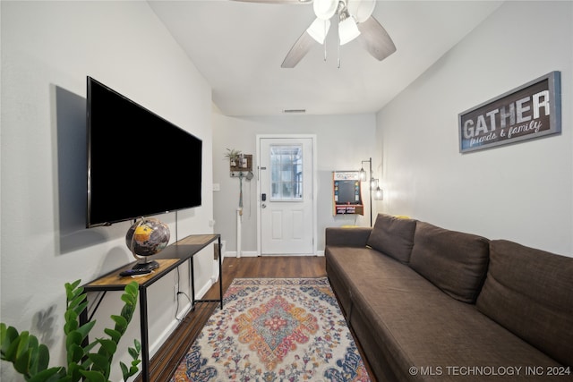 living room with dark wood-type flooring and ceiling fan