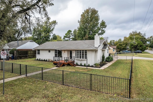 single story home with a front yard and a deck