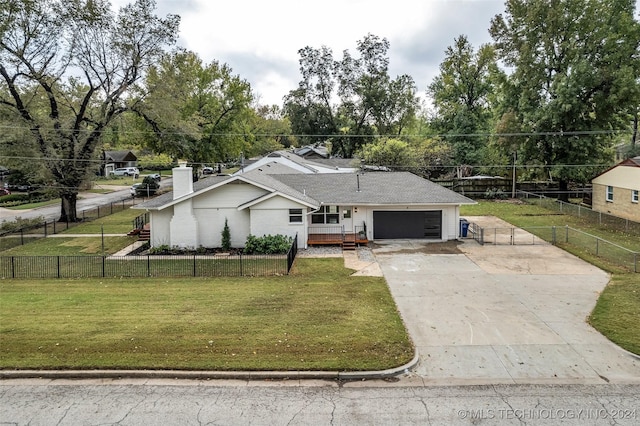 view of front of property featuring concrete driveway, a fenced front yard, a chimney, an attached garage, and a front yard