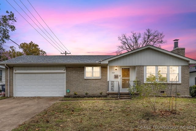 ranch-style house with a garage and a yard