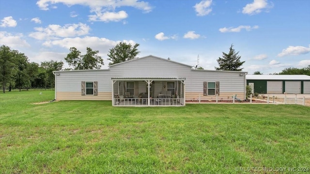 rear view of property featuring a yard and a sunroom