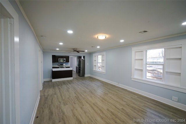 unfurnished living room featuring ceiling fan, wood-type flooring, and ornamental molding