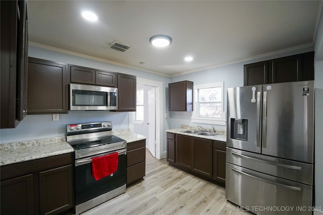 kitchen with ornamental molding, stainless steel appliances, light hardwood / wood-style floors, and sink