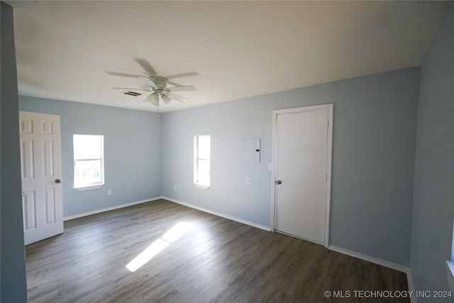 unfurnished room with ceiling fan, dark hardwood / wood-style floors, and electric panel