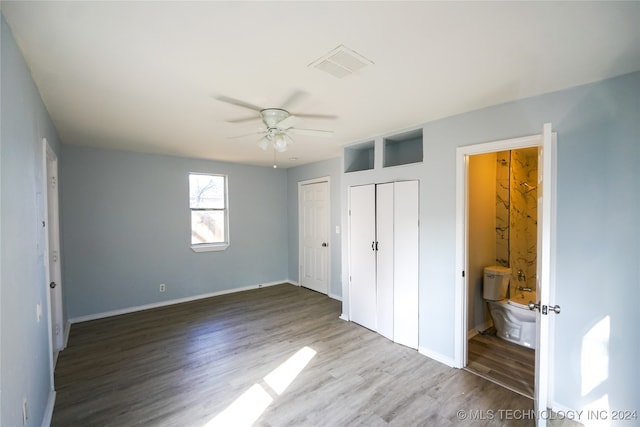 unfurnished bedroom featuring wood-type flooring, ceiling fan, and ensuite bathroom