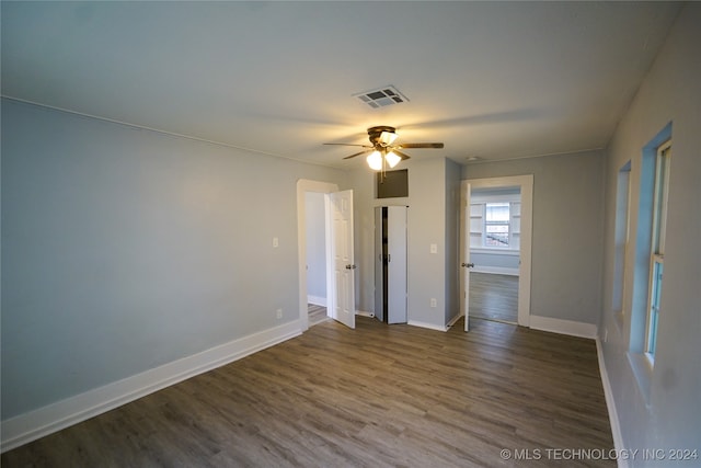 empty room with dark wood-type flooring and ceiling fan