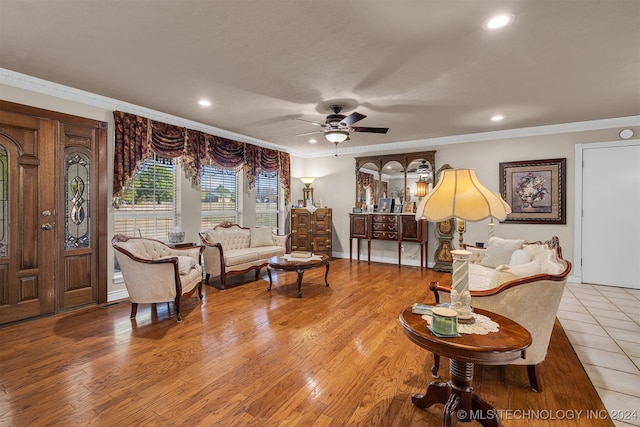 living room featuring ornamental molding, light wood-type flooring, and ceiling fan