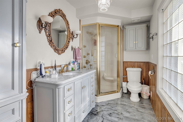 bathroom with toilet, an inviting chandelier, wooden walls, an enclosed shower, and vanity