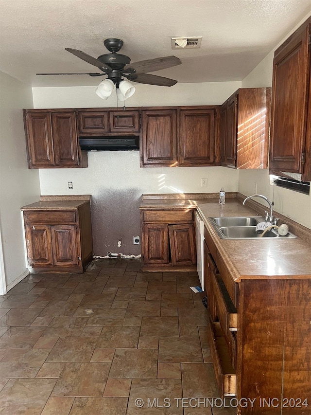 kitchen featuring dishwasher, sink, ceiling fan, and a textured ceiling