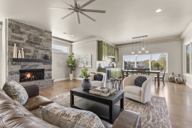 living room featuring a wealth of natural light, light hardwood / wood-style flooring, and ornamental molding