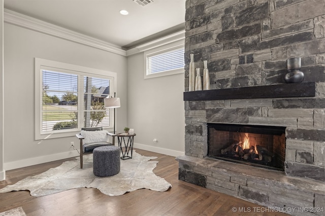 sitting room featuring a fireplace, hardwood / wood-style floors, and crown molding