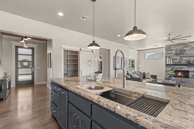 kitchen with pendant lighting, a barn door, sink, and dark wood-type flooring