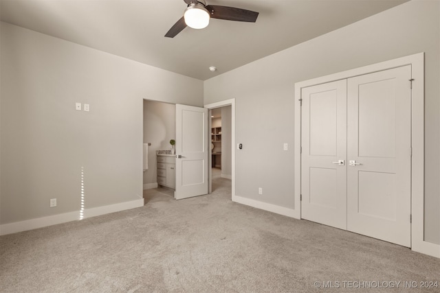 unfurnished bedroom with ceiling fan, light colored carpet, connected bathroom, and a closet