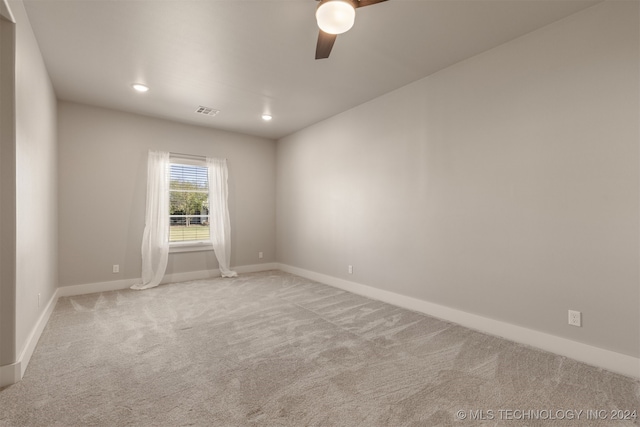 carpeted spare room featuring ceiling fan