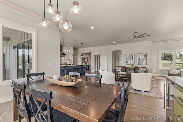 dining room with hardwood / wood-style floors, ceiling fan, and crown molding