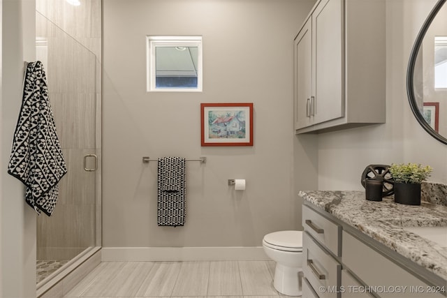 bathroom featuring tile patterned floors, vanity, an enclosed shower, and toilet