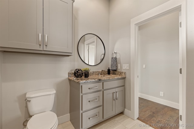 bathroom with vanity, hardwood / wood-style flooring, and toilet