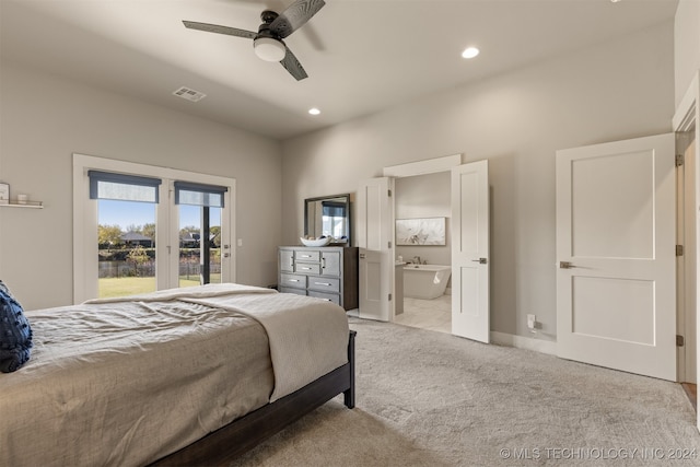 bedroom featuring light carpet, ensuite bathroom, and ceiling fan