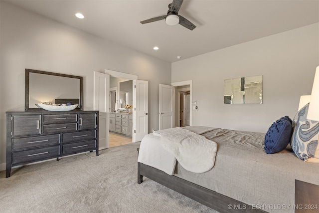 bedroom featuring ensuite bathroom, ceiling fan, and light colored carpet