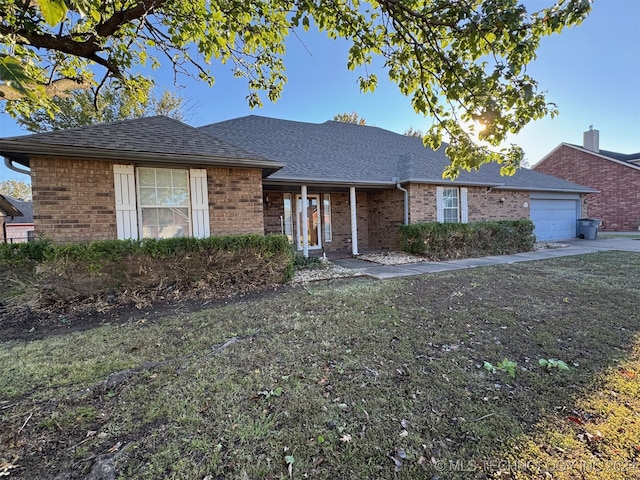 single story home with a garage and a front lawn