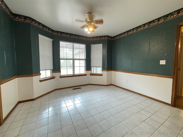 tiled empty room with ceiling fan