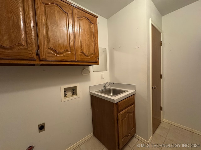 laundry room featuring hookup for an electric dryer, washer hookup, light tile patterned floors, cabinets, and sink