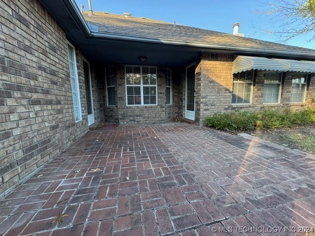 view of exterior entry featuring a patio area