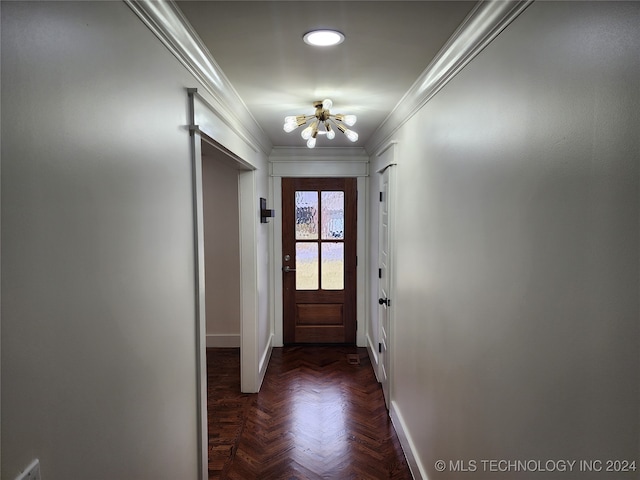 doorway with dark parquet floors, a chandelier, and crown molding