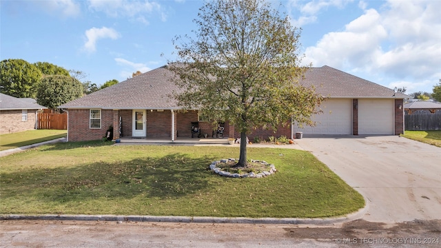 ranch-style house featuring a front yard, a porch, and a garage