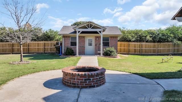 view of front of home with a fire pit, a patio, and a front lawn