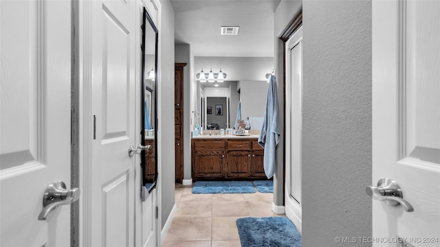 bathroom featuring tile patterned flooring, vanity, and walk in shower