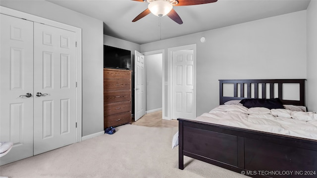 bedroom with ceiling fan, a closet, and light colored carpet