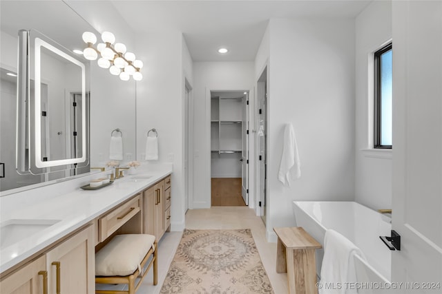 bathroom featuring vanity, a tub, and tile patterned flooring