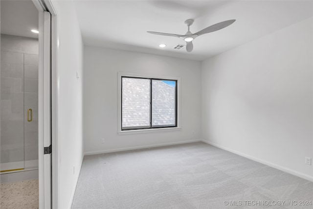 carpeted spare room featuring ceiling fan