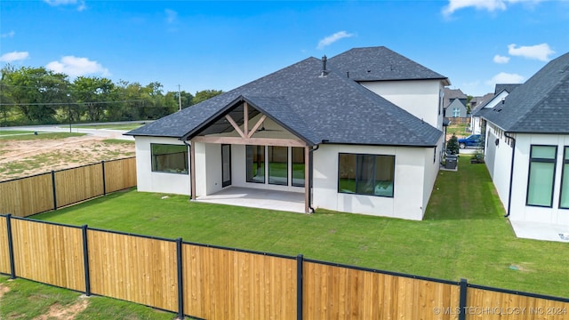 rear view of house with a lawn and a patio