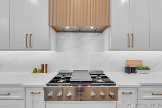 kitchen featuring white cabinetry, light stone counters, and backsplash