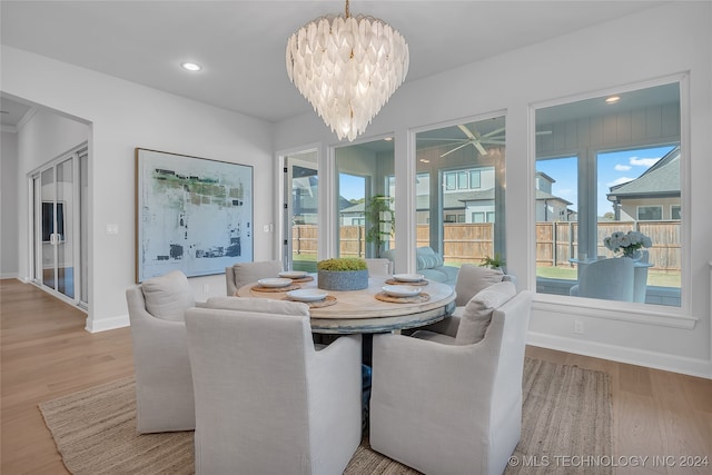 dining area with an inviting chandelier and light hardwood / wood-style flooring