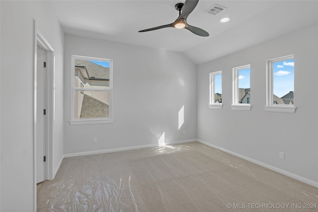 empty room with ceiling fan, lofted ceiling, and light colored carpet