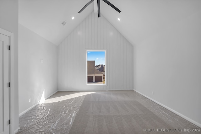 additional living space featuring light carpet, ceiling fan, beam ceiling, high vaulted ceiling, and wooden walls