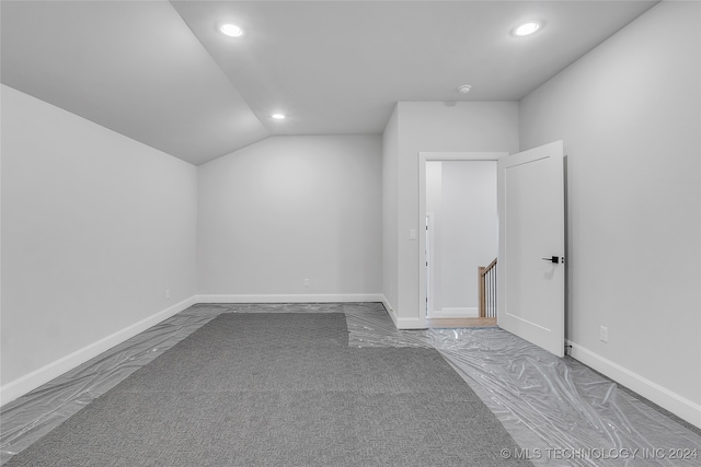 empty room featuring vaulted ceiling and carpet